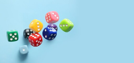 Flying colorful game dices on blue background with space for text