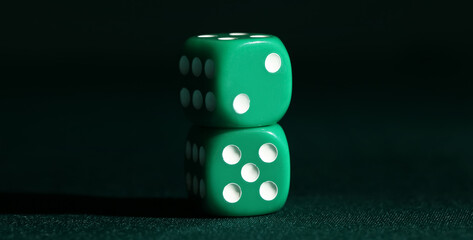 Green dices on dark background, closeup