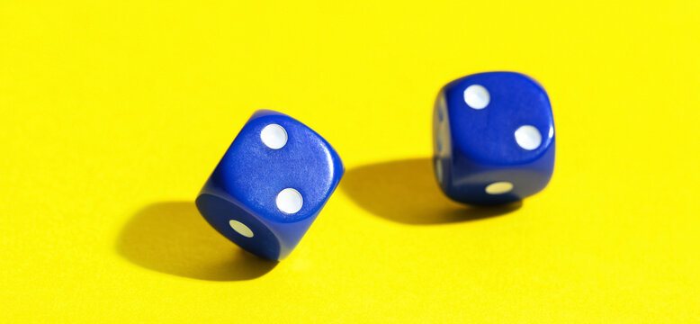 Game dices on yellow background, closeup