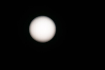 Circular moon high in sky on background with copy-space,
