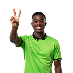 Naklejka premium Smiling young African American man in a vibrant green polo shirt making a peace sign, expressing happiness and victory against a transparent background.