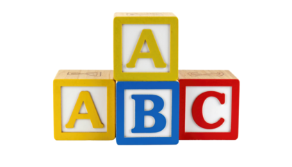 Colorful wooden toy blocks stacked featuring the letters "A", "B", and "C" against a stark black backdrop