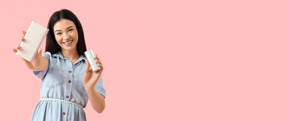 Beautiful young woman with modern power banks on pink background