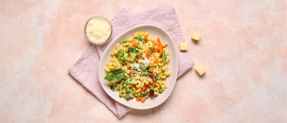 Plate with tasty pasta primavera and cheese on beige background