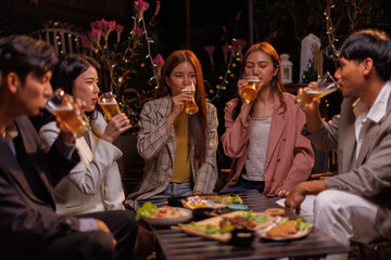 Happy Group of people Asian friends Drinking beer outdoors at the brewery for the New Year festival night time
people