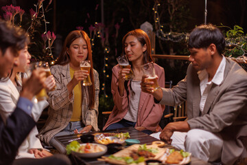 Happy Group of people Asian friends Drinking beer outdoors at the brewery for the New Year festival night time
people