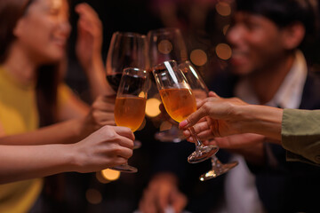 Group of people toasting with champagne glasses at a celebration. Hands holding champagne, clinking glasses. Festive atmosphere, joyful celebration, champagne toast. People toasting with champagne.
