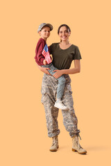 Little boy with USA flag and his military mother on beige background. Veterans Day celebration
