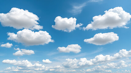 Fototapeta premium Fluffy white clouds drift across bright blue sky, creating peaceful and serene atmosphere