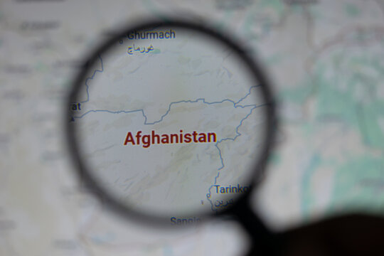 A magnifying glass highlights the country of Afghanistan on a world map, representing focus on its national boundaries, geopolitical relevance, and role in international geography and travel.