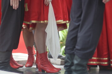  traditional dancer's legs, with bright red boots and skirt (women) as opposed to black trousers and boots (men).