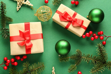 Christmas gift boxes with fir branches, balls and viburnum on green background
