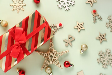 Christmas gift box with wooden toys and balls on green background