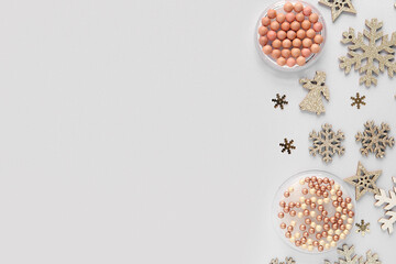 Beautiful Christmas composition with decorative snowflakes, highlighter and blush pearls on light background