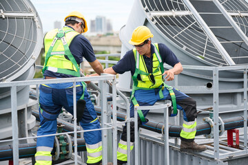 Construction workers collaborating on a rooftop, emphasizing safety and teamwork in an industrial...