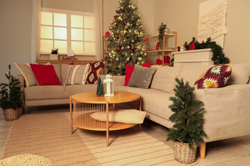 Interior of living room with  grey sofa, Christmas tree and festive decorations at evening