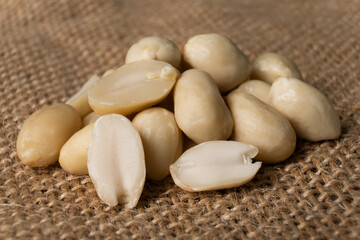 Macro Shot of Shelled Peanuts Piled on Brown Burlap Fabric Background
