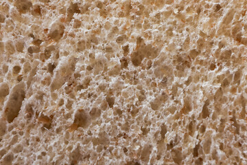 Macro background texture of brown bread crumb showing wholesome, healthy, and natural food concept. This detailed slice of organic, dietary bakery bread rustic food