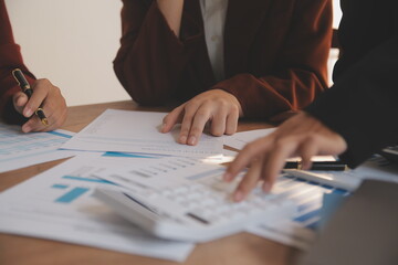 Group of confident business people point to graphs and charts to analyze market data, balance sheet, account, net profit to plan new sales strategies to increase production capacity.