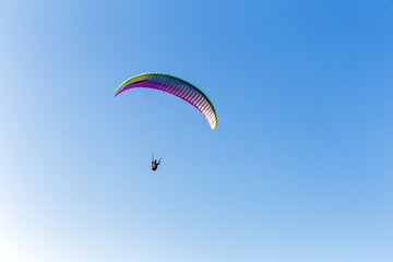 Paragliding against the backdrop of blue sky
