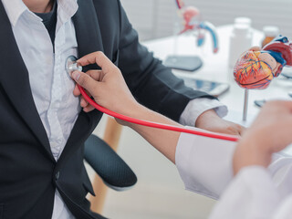 Doctor uses stethoscope to examine patient's body to diagnose and recommend treatment method. Medical concept. Female doctor is examining patient's body with stethoscope to examine heart.
