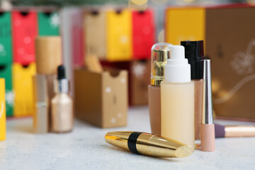 Makeup products on table against blurred Christmas Advent calendar, closeup
