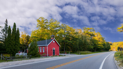 Old little red school building along the highway in Michigan countryside.