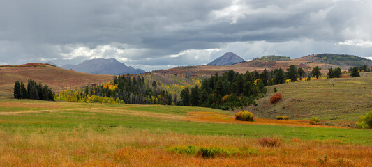 Panoramic view of scenic meadow and mountain landscape in Colorado San Juan mountains during autumn time.