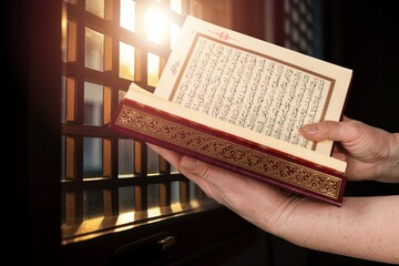 Muslim man reading quran book with faith