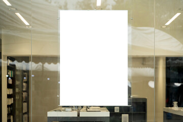 Blank white poster on glass wall in modern store interior for advertising, branding, and marketing...