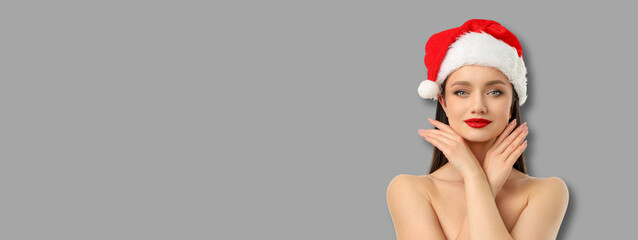 Woman adorned in a Santa hat poses with a cheerful expression