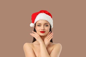 Woman poses with hands on cheeks wearing Christmas hat