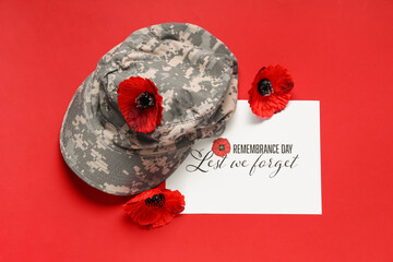 Poppy flowers with uniform and card on red background. Remembrance Day