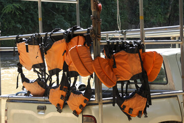 Orange life jacket safety equipment hanging on pickup truck for transport to an outdoor water sport adventure activity, sense of readiness for fun on water