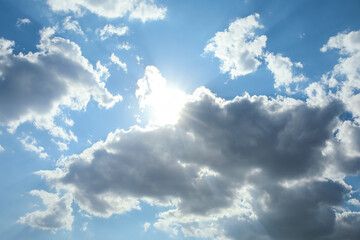 Obraz premium Beautiful view of blue sky with sun behind clouds as background