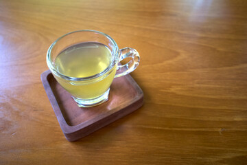A glass of white tea (silver needle white tea) on a wooden table