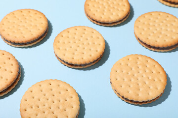 Tasty sandwich biscuits with chocolate cream on blue background