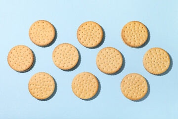 Tasty sandwich biscuits with chocolate cream on blue background