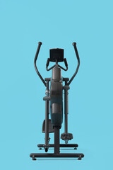 Modern elliptical machine on blue background