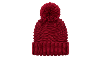 Knitted winter hat featuring a prominent pom-pom topper sits isolated against a stark black background.