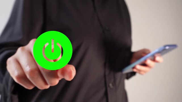 A businesswoman holding a smartphone while pointing forward to a power button with the word