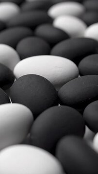 Arrangement of Smooth Black and White Oval Stones in a Textured Pattern with Soft Lighting Creating a Zen Balance
