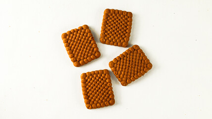 four delicious crispy biscuits with chocolate flavor in square shape on a white background