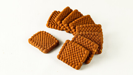 Stack of delicious crispy biscuits with chocolate flavor in square shape on a white background
