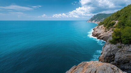 Obraz premium Serene Coastal Vista Overlooking Turquoise Waters and Rocky Cliffs under a Clear Blue Sky with Wispy Clouds in a Scenic Nature Setting