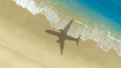 Aerial view of shadow passenger plane silhouette and sandy beach blue sea with waves at sea beach summer vacation sea travel concept	