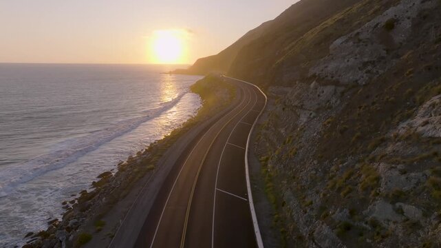 4K footage of the sun setting over the Pacific Ocean near Point Mugu along California&rsquo;s Pacific Coast Highway. Captured at golden hour, the scene features warm light illuminating coastal cliffs, waves