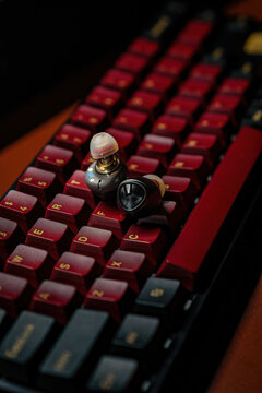 IPOH, MALAYSIA &ndash; OCTOBER 29, 2025: Close-up of a black in-ear monitor (IEM) on a black and red mechanical keyboard.