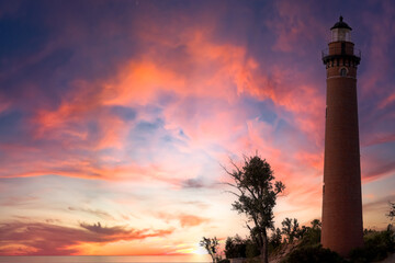 Little sable point light house along Lake Michigan against sunset sky
