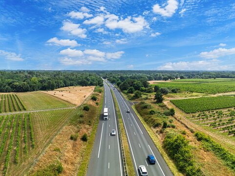 Stunning aerial view of a highway winding through the picturesque French countryside in Nouvelle-Aquitaine, France. Perfect for travel, rural landscapes, and summer vacations in France.